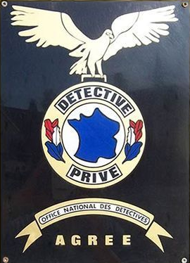 Panneau noir avec l'emblème  DÉTECTIVE PRIVÉ, une carte de France, un aigle et l'inscription  ACCEPTÉ