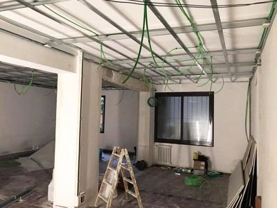 Una habitación en construcción con una escalera y una ventana.