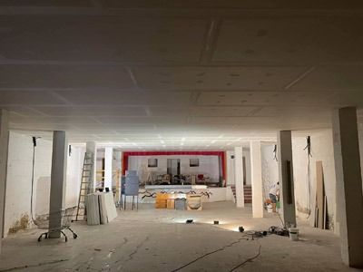 Una gran sala con columnas y un techo que está siendo remodelado.