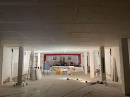 Una gran sala con columnas y un techo que está siendo remodelado.