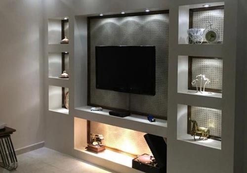 Una sala de estar con un televisor de pantalla plana montado en la pared.