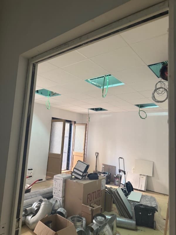 Habitación parcialmente renovada con herramientas, cajas y trabajos en el techo en curso.