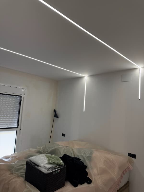 Dormitorio en reforma con luces LED en el techo y muebles cubiertos de plástico.