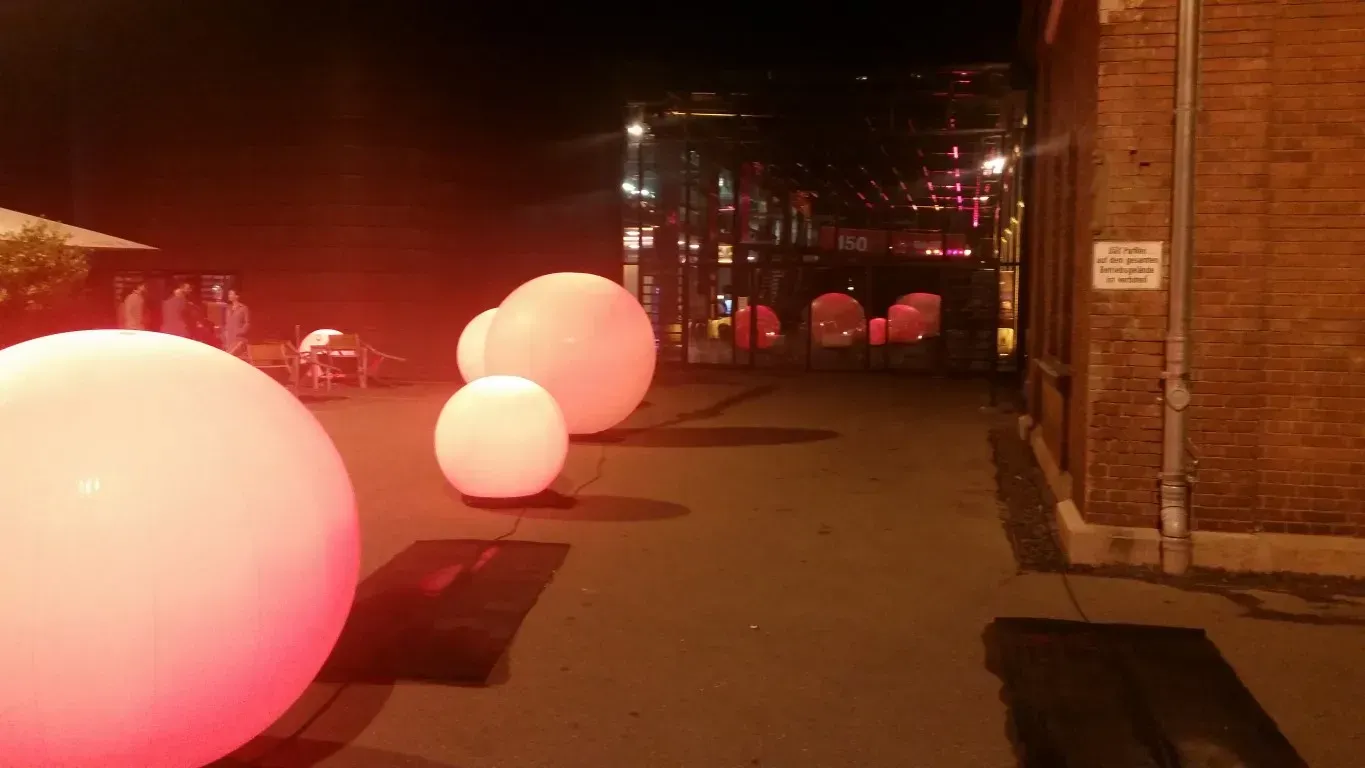 Eine Reihe von roten und weißen Kugeln, vor einer Eventlocation