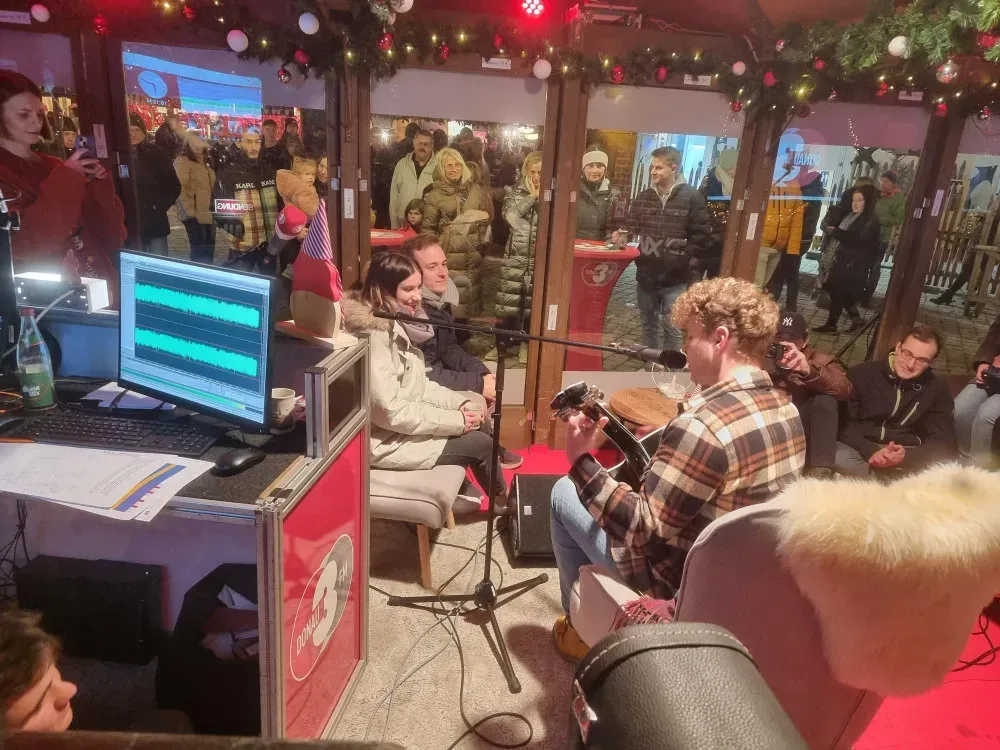 Liveband in einem Glashaus des Radiosenders Donau 3 FM auf einem Weihnachtsmarkt