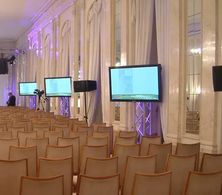 Ausstellungssaal mit Stühlen und vielen Bilschirmen