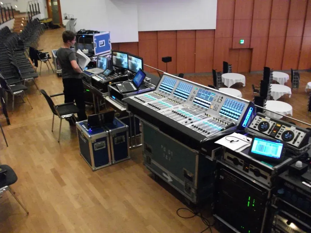 Equipment der Veranstaltungstechnik mit Lautsprechern, Mischpulten, Lampen und Laptops