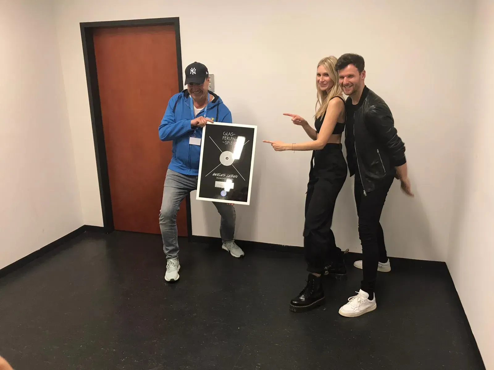 Die Band Glasperlenspiel hält, nach einem Konzert, eine Auszeichnung hoch