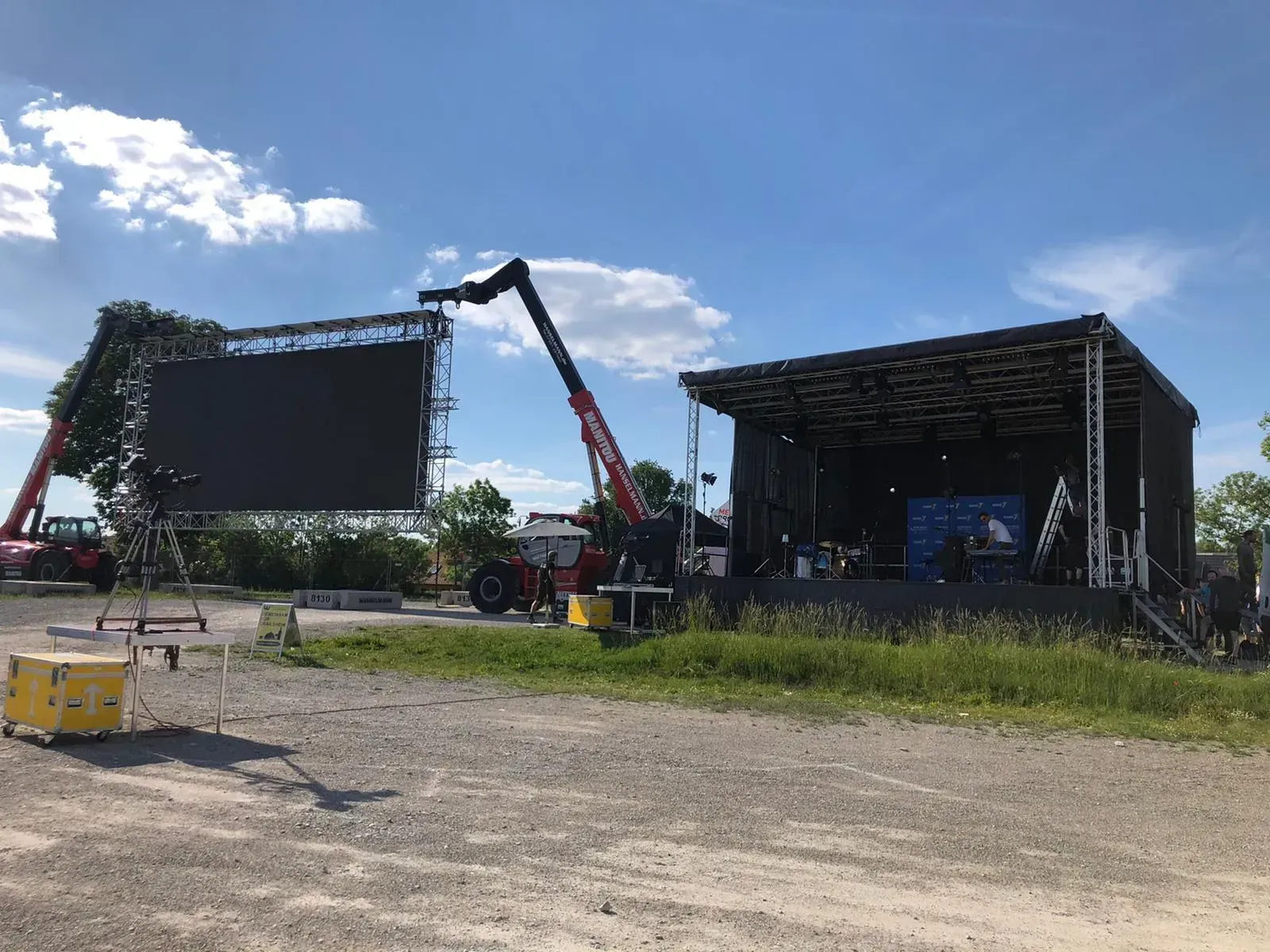 Auf einem Feld wird ein riesiger LED-Bildschirm aufgebaut neben der Bühne