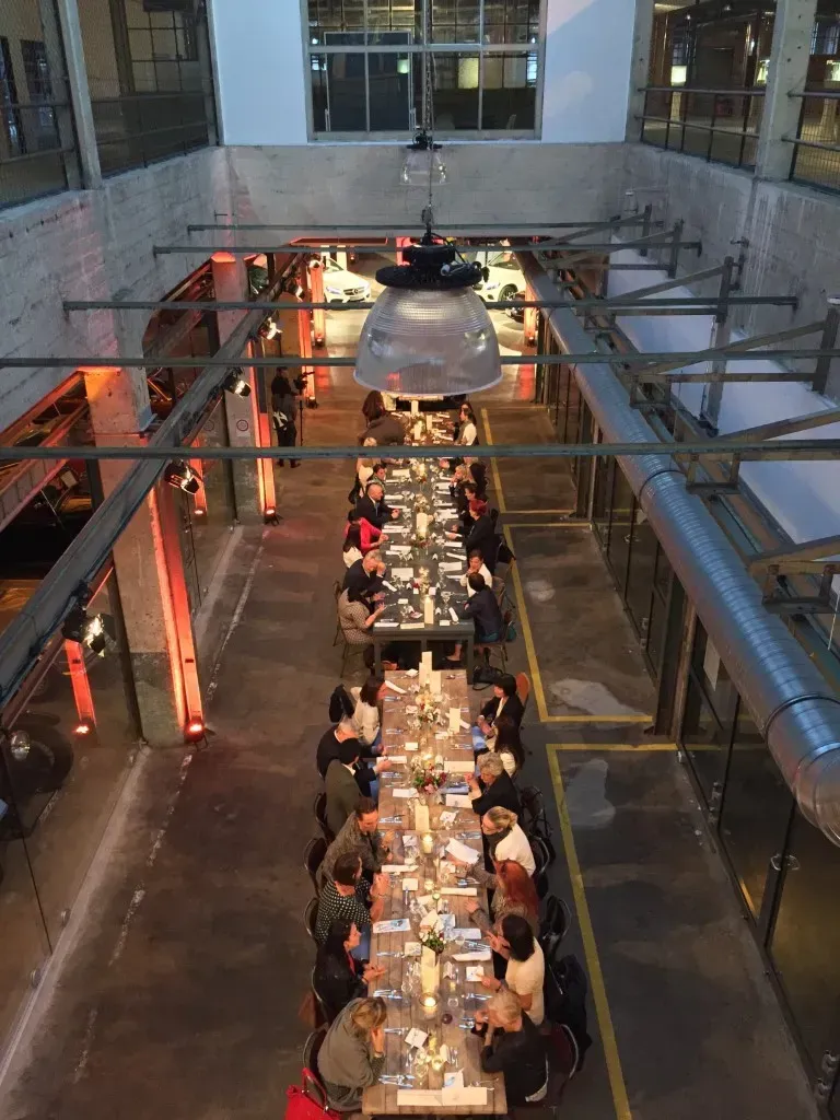 Hochzeitsgäste sitzen an einem langen Tisch in einem Restaurant