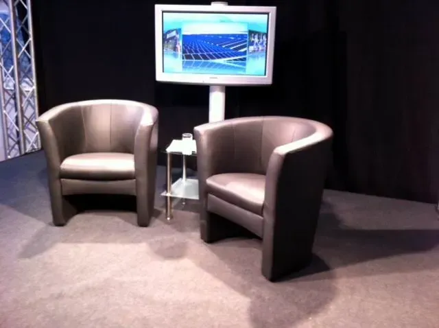 Eine Moderationslocation mit zwei gepolsterten Stühlen und einem Fernseher