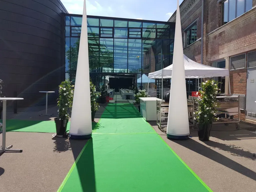 Grüner Teppich führt zu einer großen Eventlocation