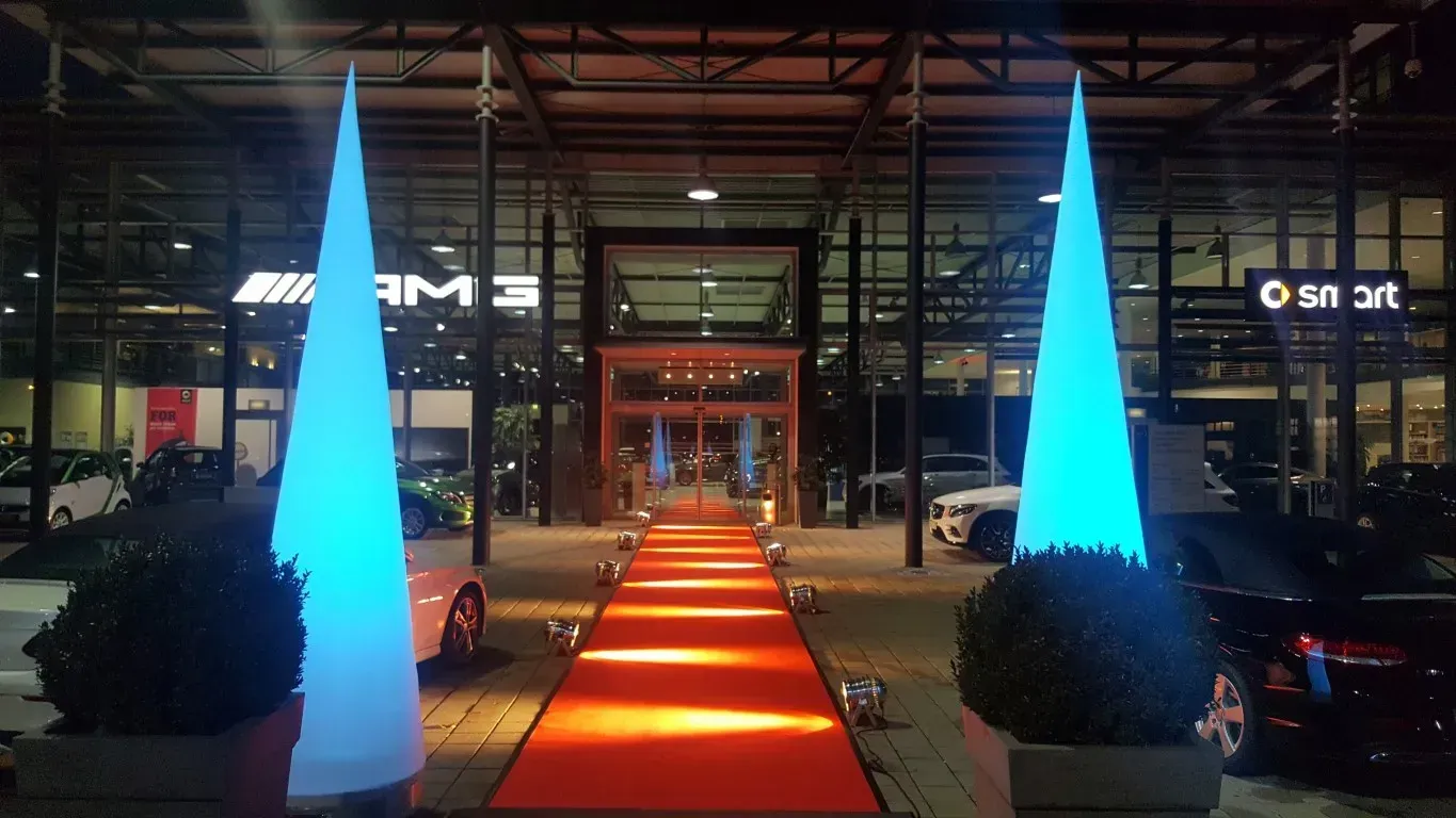 Roter Teppich mit beleuchteten Säulen im Eingangsbereich einer Ausstellung