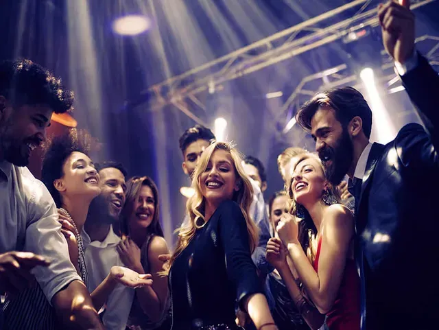 Publikum eines Events beim Tanzen mit Illuminationen des Raumes