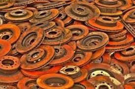 Ein Haufen rostiger Bremsscheiben und Rotoren, die übereinander gestapelt sind.