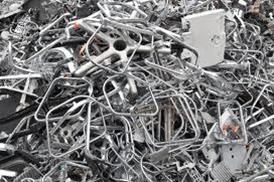 Ein Haufen Aluminiumschrott liegt auf einer schwarzen Oberfläche.