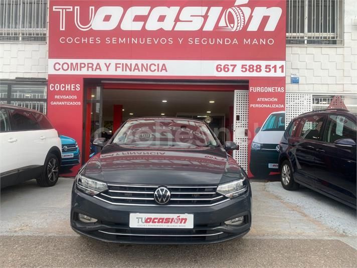 Un Volkswagen está estacionado frente a un concesionario de coches de ocasión.