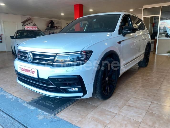 Un Volkswagen Tiguan blanco está estacionado en una sala de exposición.