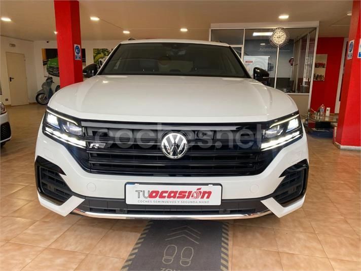 Un Volkswagen blanco está aparcado en una sala de exposición.