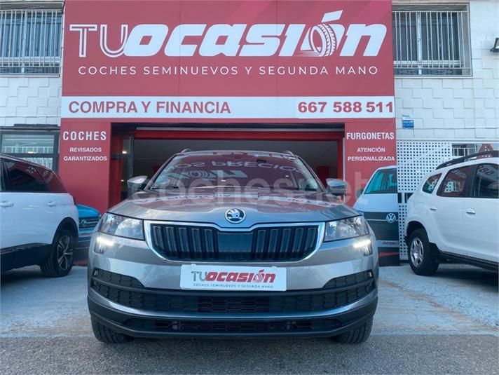 Un coche Skoda está aparcado delante de una tienda de artículos de ocasión.