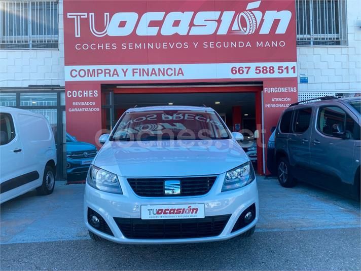 Un coche blanco está aparcado delante de una tienda llamada tu ocasion