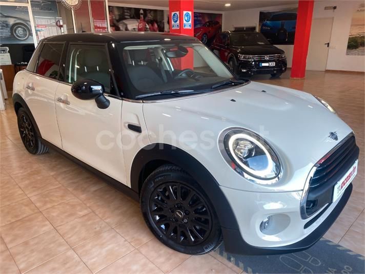 Un mini cooper blanco está estacionado en una sala de exposición