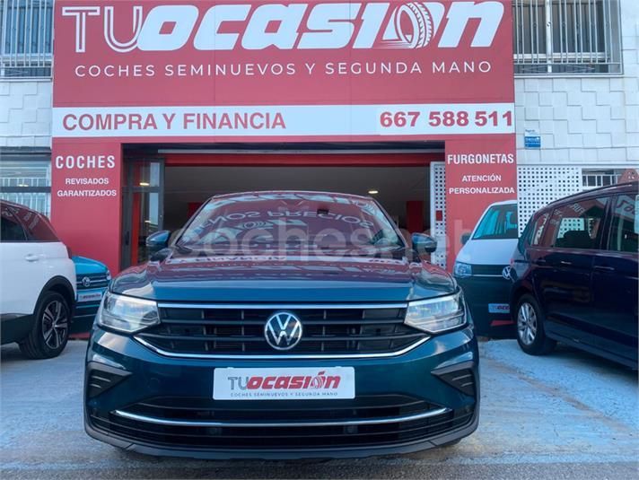 Un coche azul está aparcado delante de un edificio que dice 