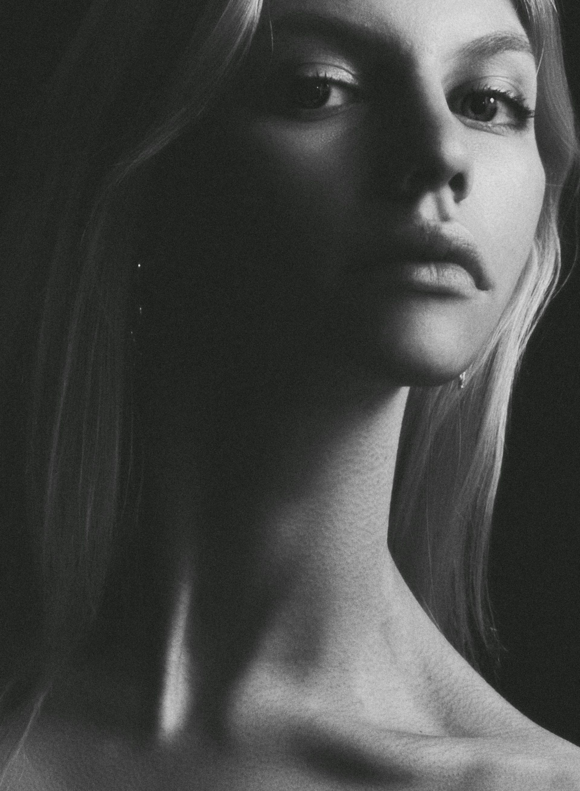 Una fotografía en blanco y negro del cuello y la cara de una mujer.