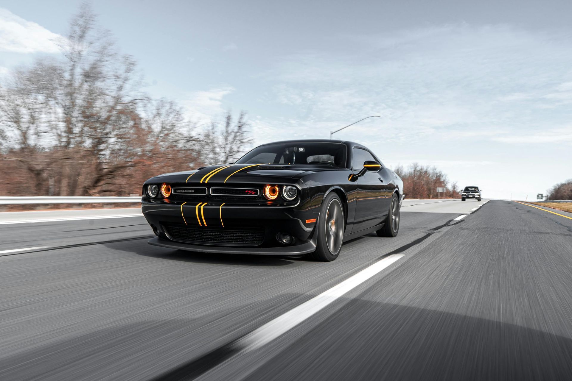 Un Dodge Challenger negro circula por una autopista.