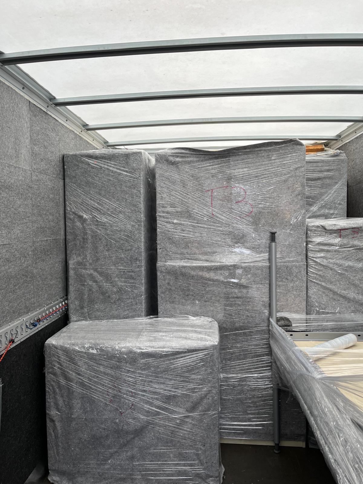 Ein Mann steht hinten in einem Anhänger.