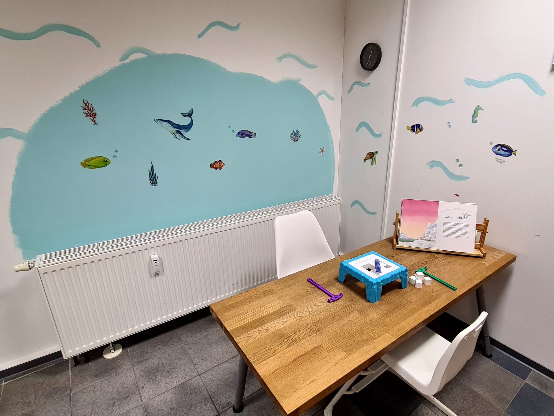 Ein Raum mit einem Tisch und Stühlen und einem Gemälde an der Wand.