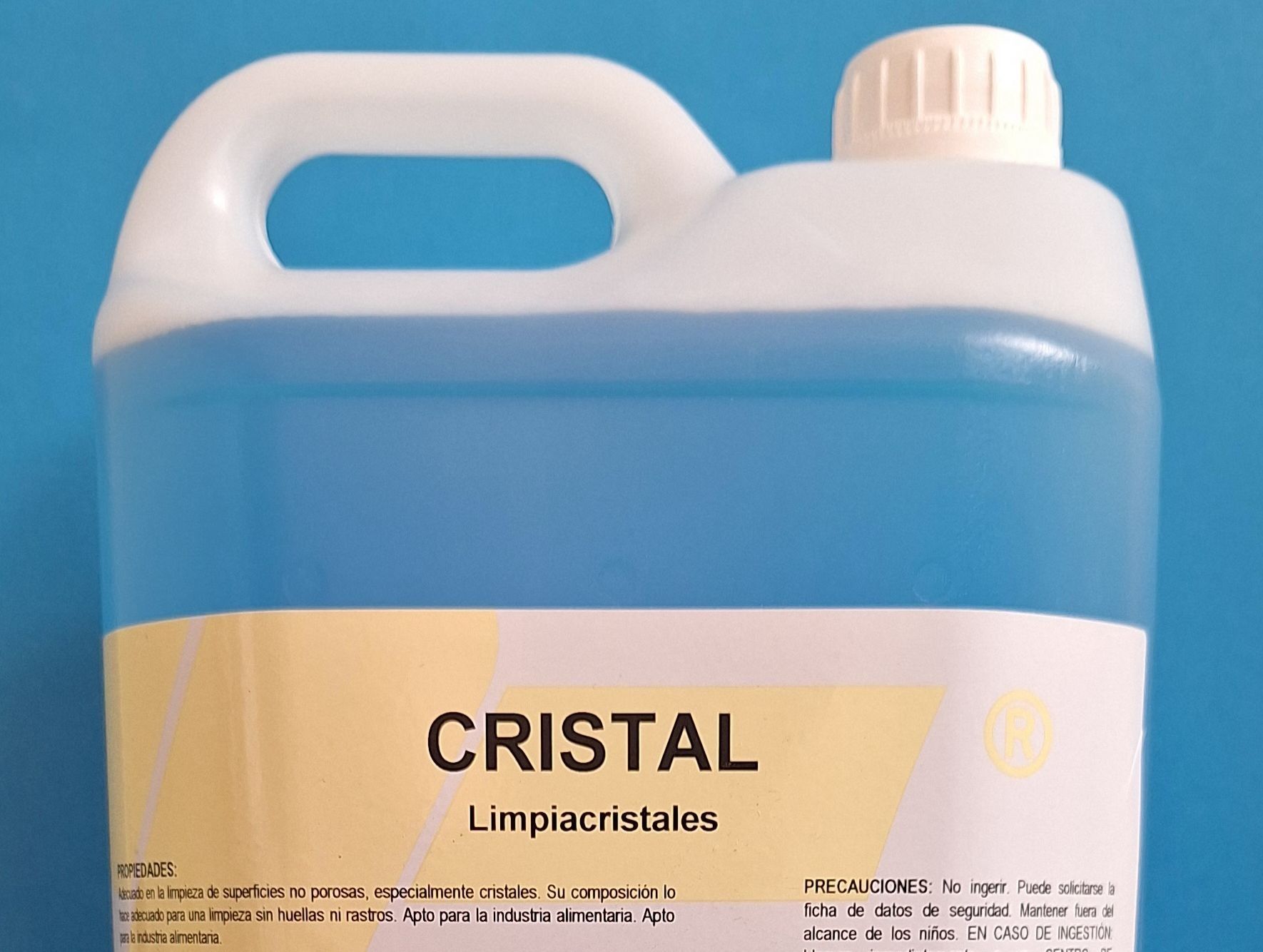 Una botella de cristal reposa sobre una superficie azul.