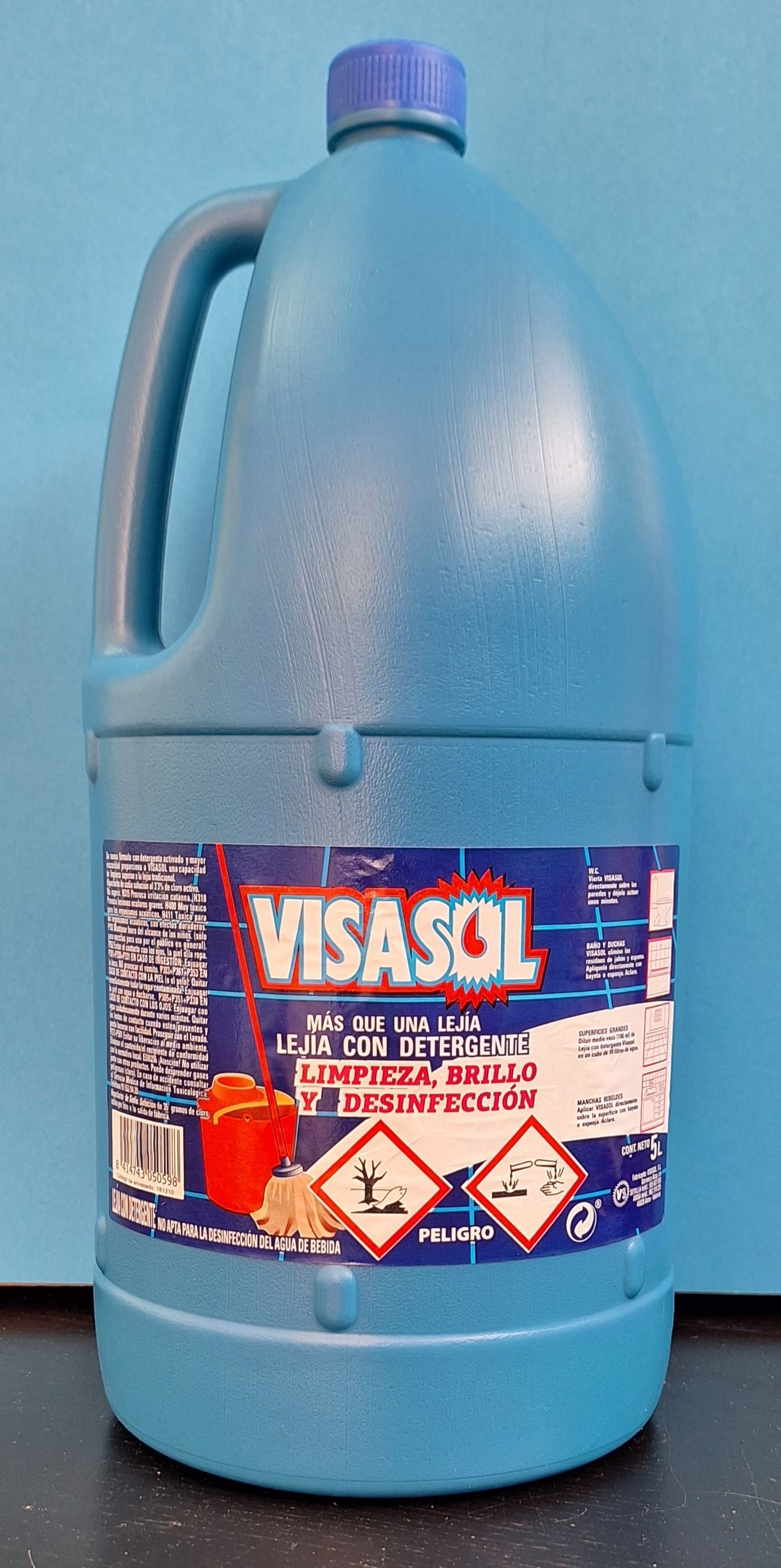Una botella azul de blanqueador Visasol está sobre una mesa.