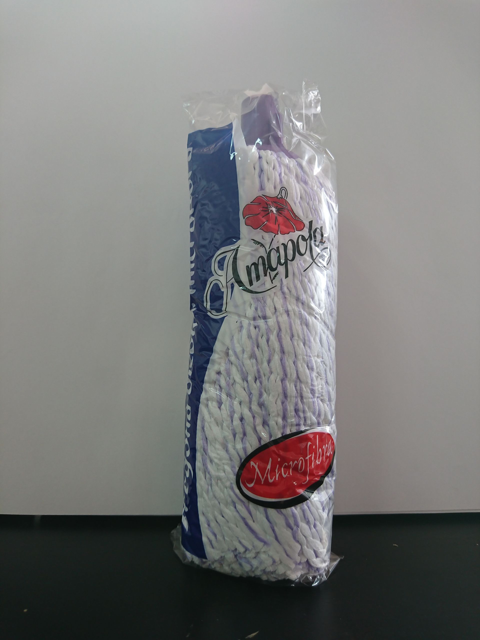Un cabezal de trapeador dentro de una bolsa de plástico está sobre una mesa.