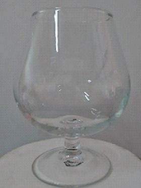 Una copa de vino vacía está sobre una mesa blanca.