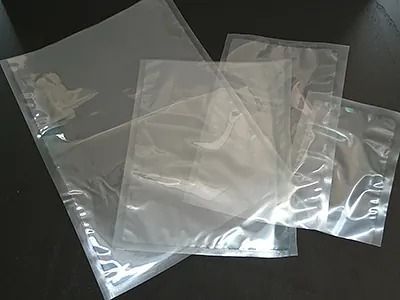 Tres bolsas de plástico transparente están colocadas una encima de otra sobre una mesa.