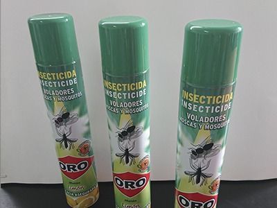 Hay tres botellas de insecticida Oro sobre una mesa.