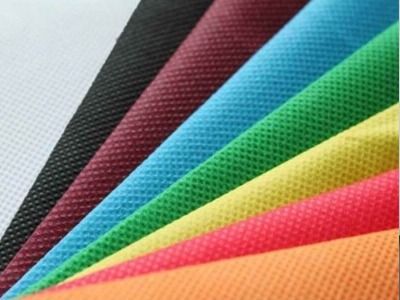 Un montón de telas de diferentes colores se apilan una encima de otra.