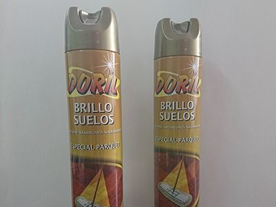 Dos botellas de brillo suelo están una al lado de la otra en una mesa.