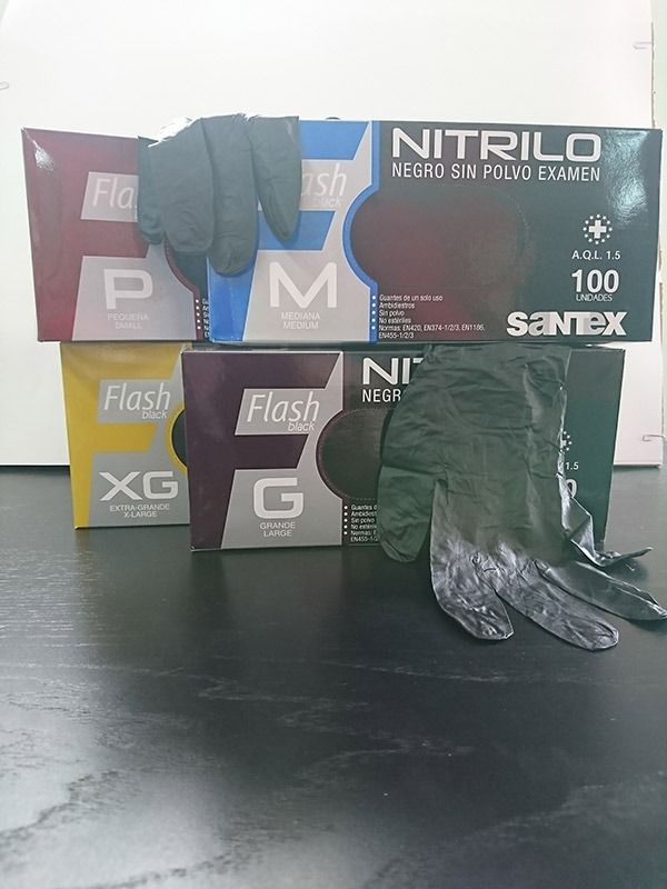 Un par de guantes de nitrilo encima de una pila de guantes de nitrilo.