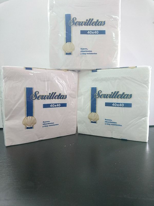 Tres cajas de servilletas están apiladas una encima de otra sobre una mesa.