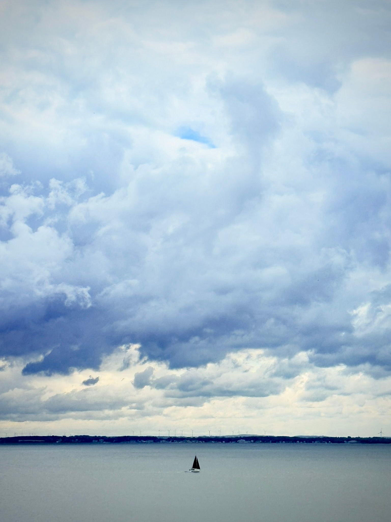 Segelboot auf der Lübecker Bucht unter dramatischem Wolkenhimmel