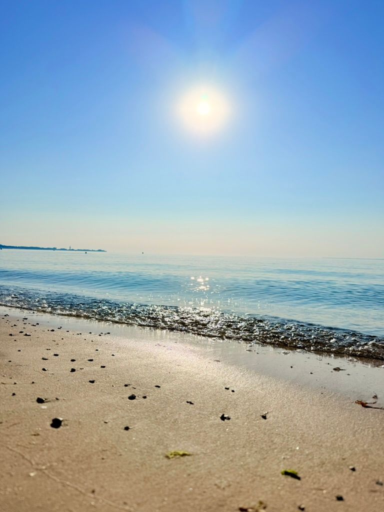 Reflektierende Sonne bei spiegelglatten Wasser in Sierksdorf an der Ostsee