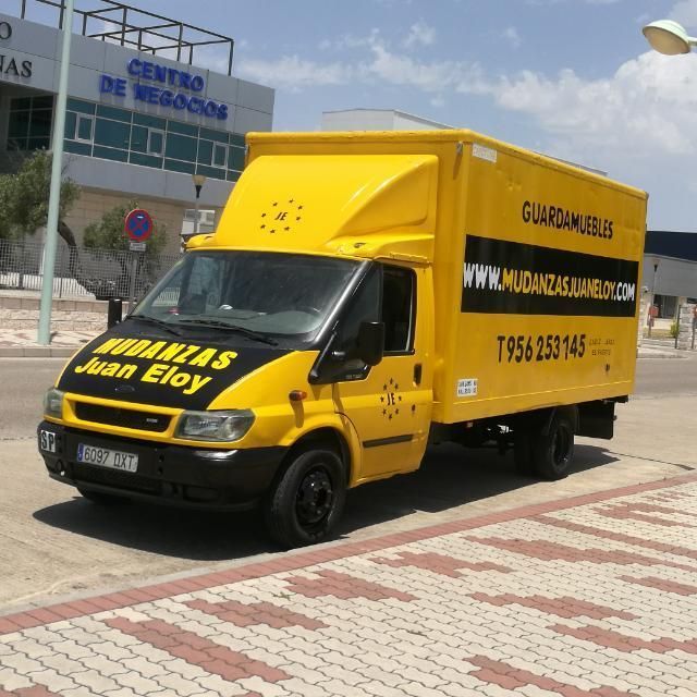 Una camioneta amarilla marca Juan Eloy está estacionada al costado de la carretera.