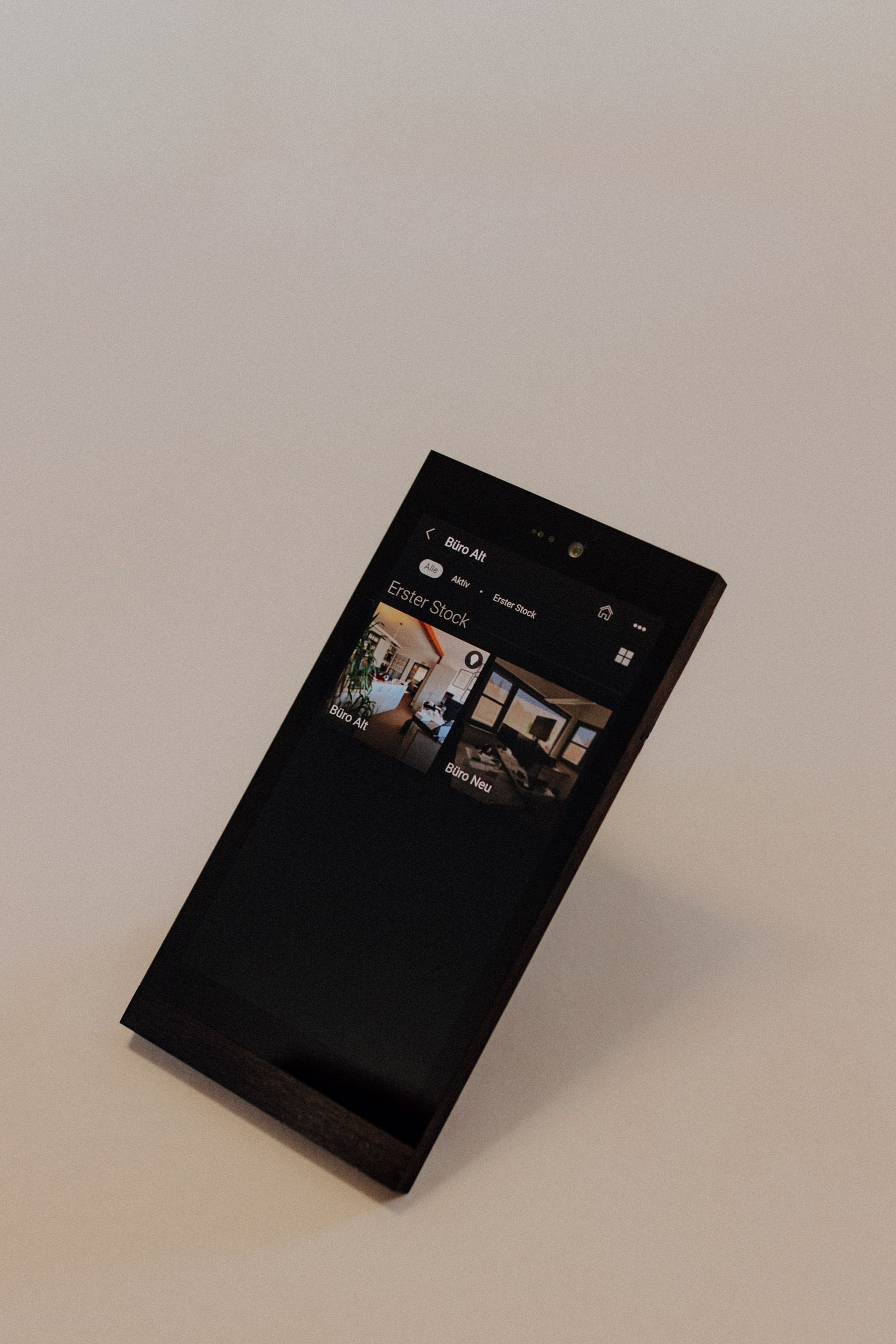 Mobiles Smart-Home-Bediengerät mit Touchscreen auf heller Oberfläche