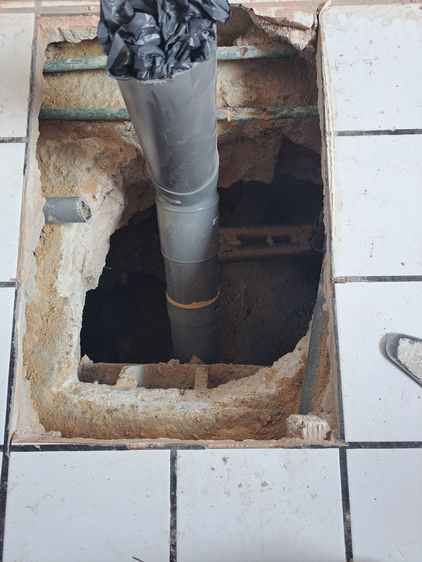 Una tubería sale de un agujero en el suelo.