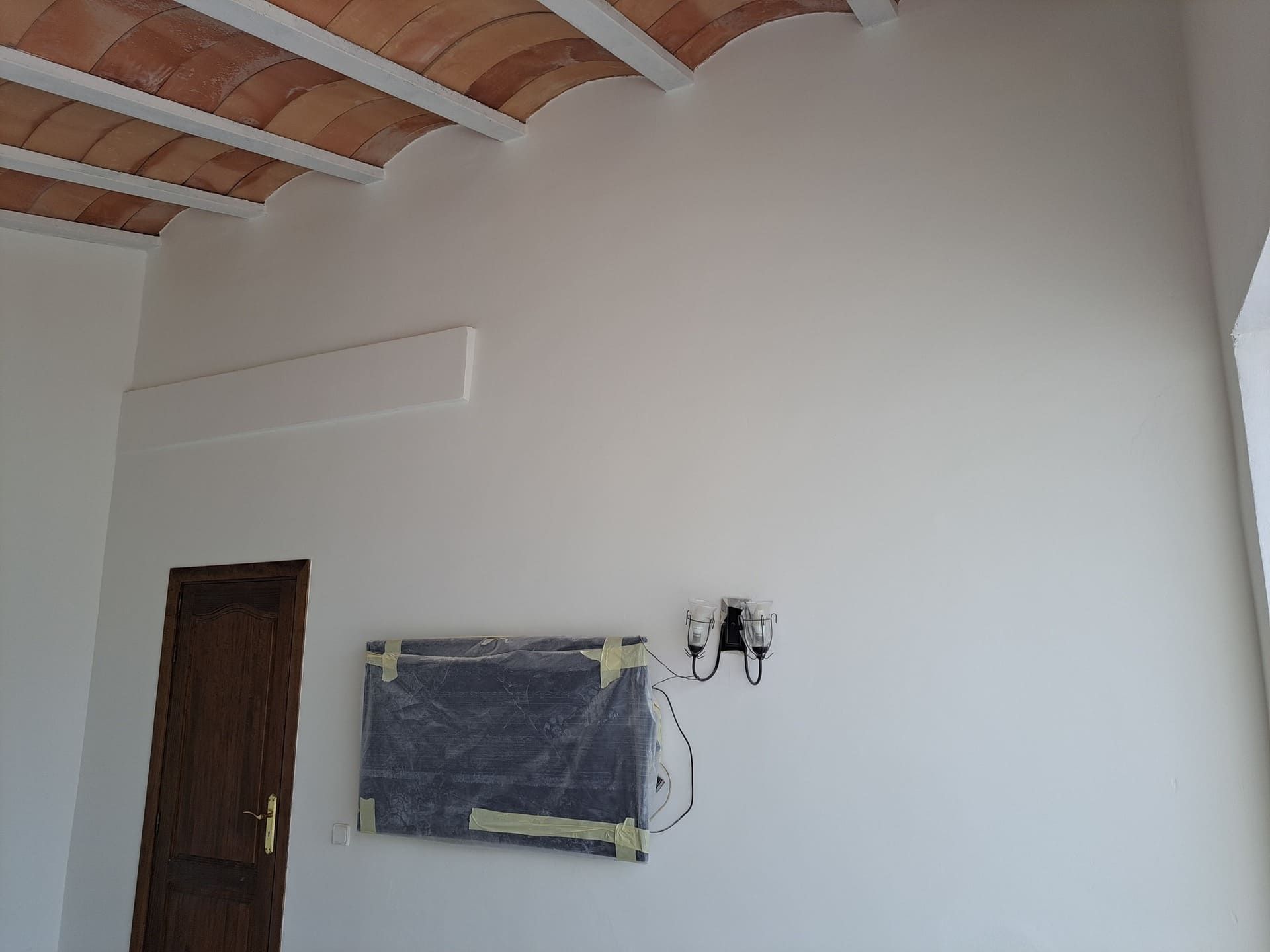 Una pared blanca con un televisor montado en ella.