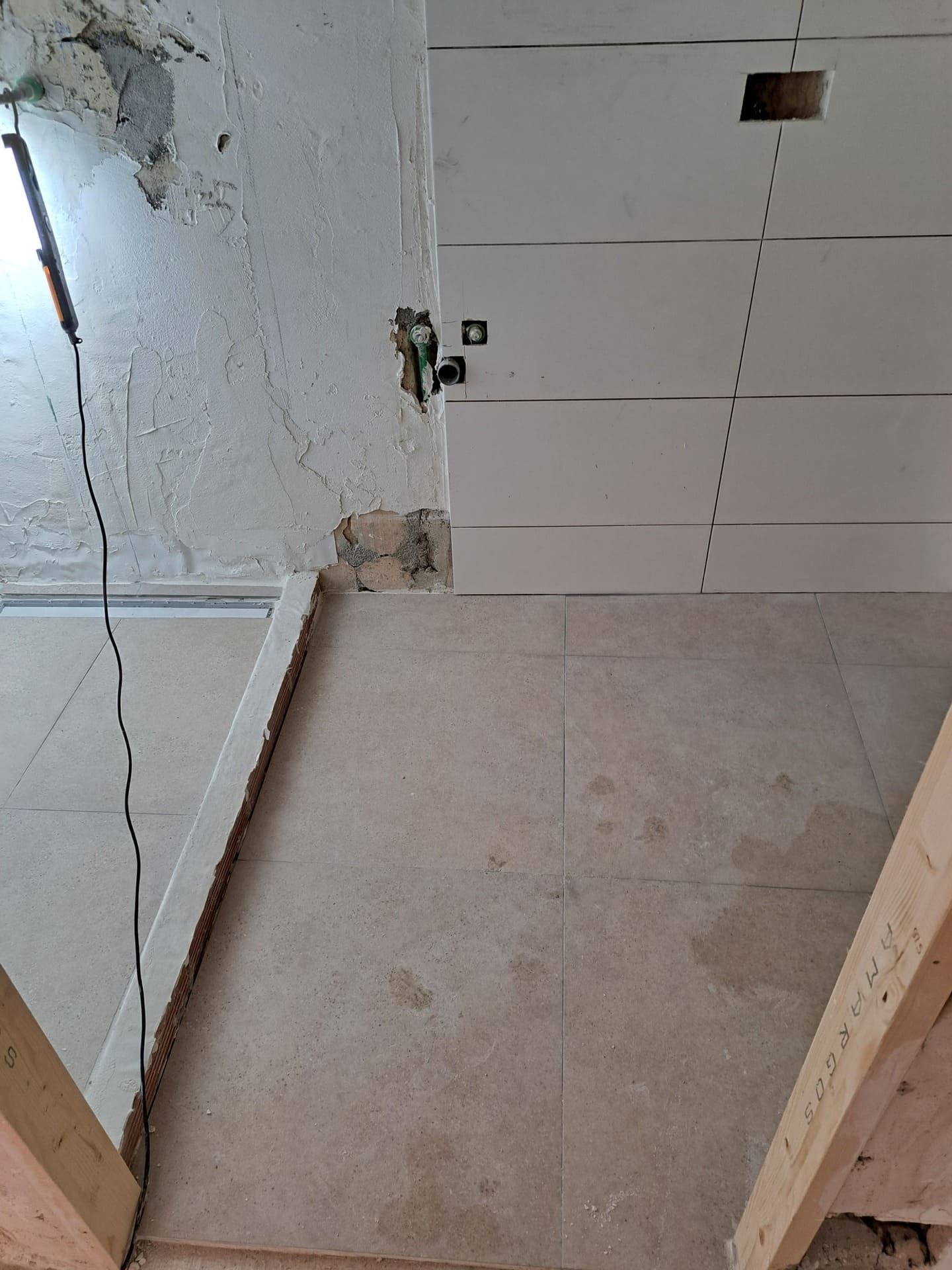 Se está construyendo una escalera en una habitación con baldosas blancas en el suelo.