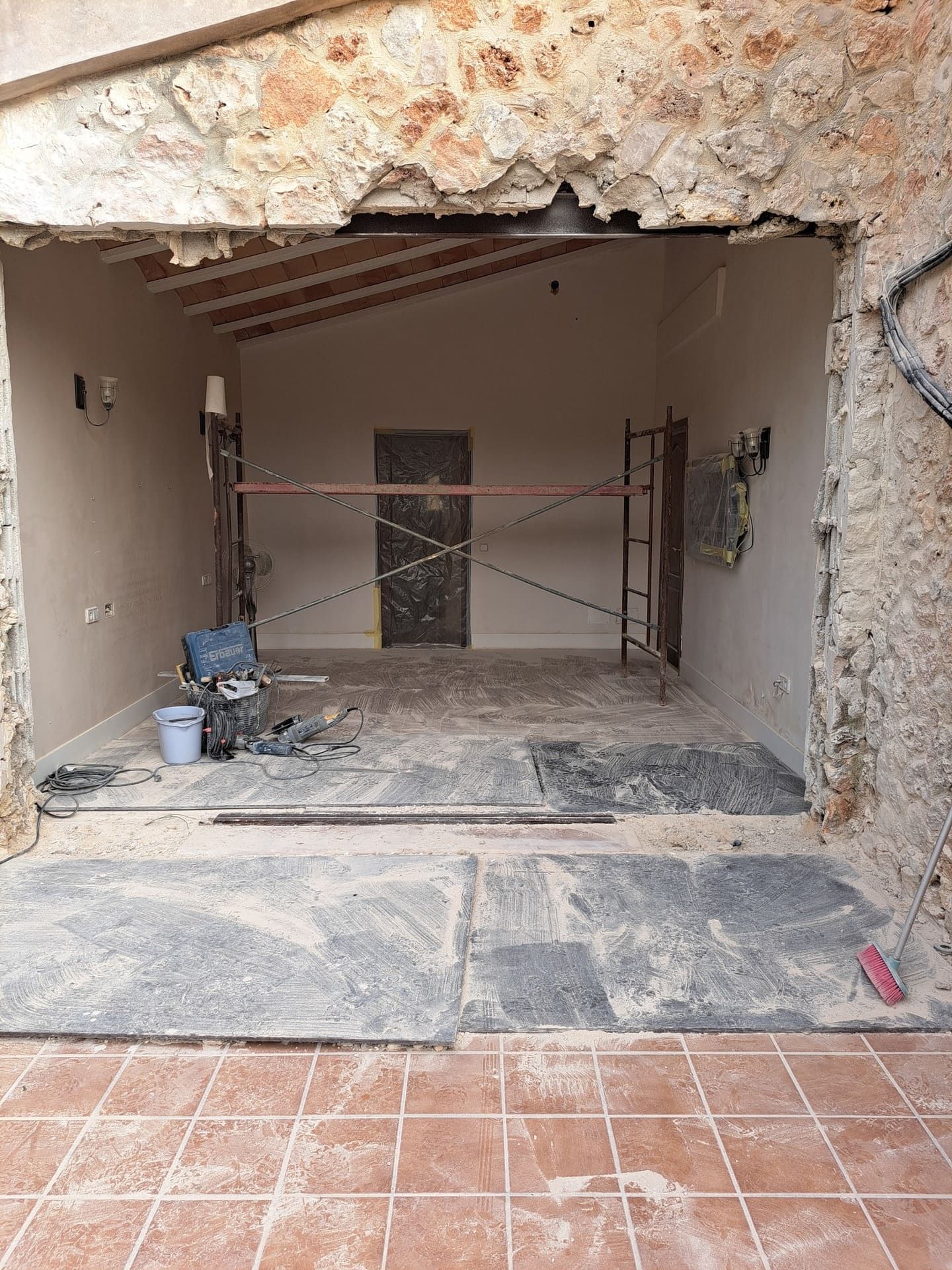 Una habitación que está siendo remodelada con un andamio al fondo.