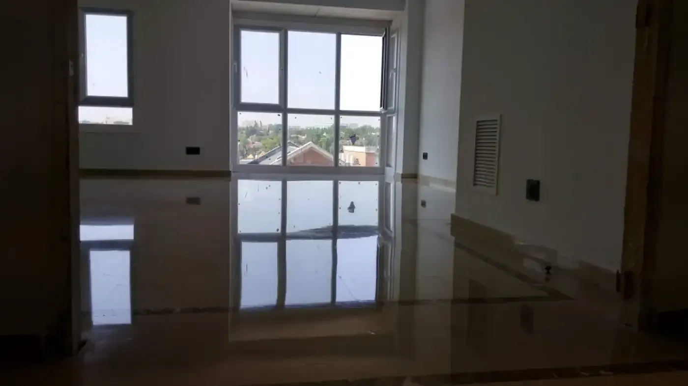 Habitación vacía con suelos y ventanas brillantes y reflectantes.